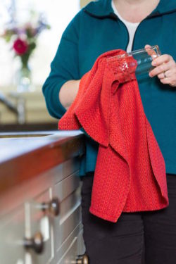 drying a glass with a Sunset kitchen towel